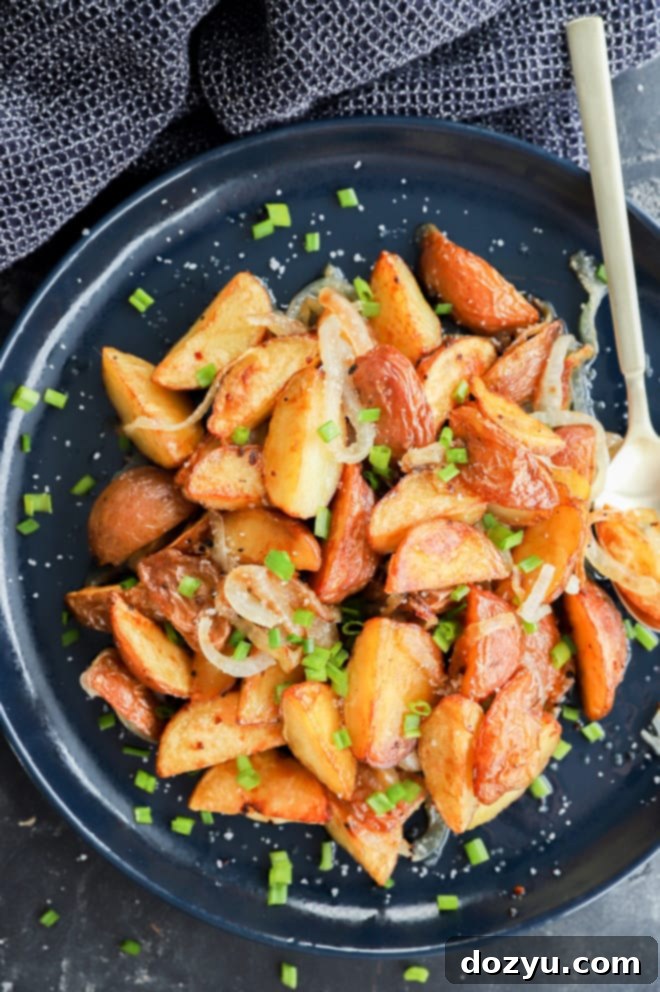 Golden Oven-Fried Potatoes and Onions 8 oven fried potatoes and onions on plate with chives and salt