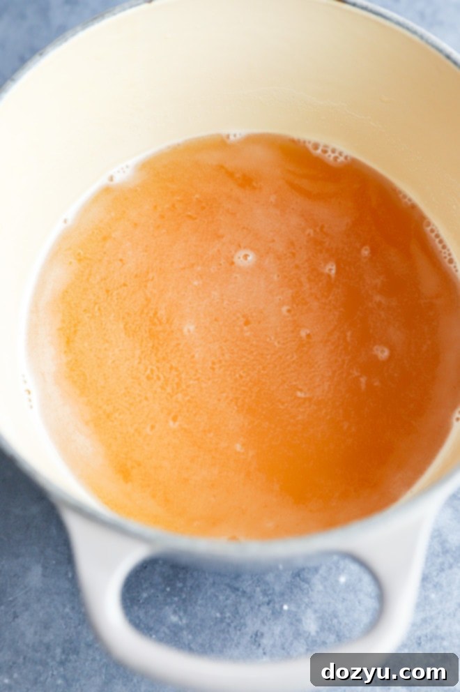 making honey simple syrup in a small saucepan, showing the ingredients gently simmering
