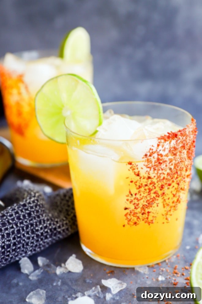 Two passion fruit margaritas in glasses with Tajin rim and lime wheel garnish, ready to be enjoyed.