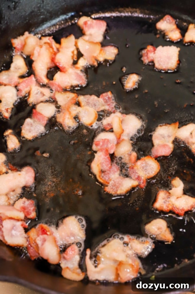 Crispy bacon cooking in a hot skillet, ready to be drained