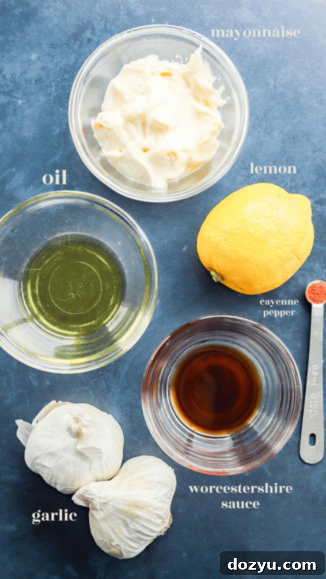 Array of fresh ingredients for Roasted Garlic Aioli, including garlic heads, lemon, mayonnaise, and seasonings.
