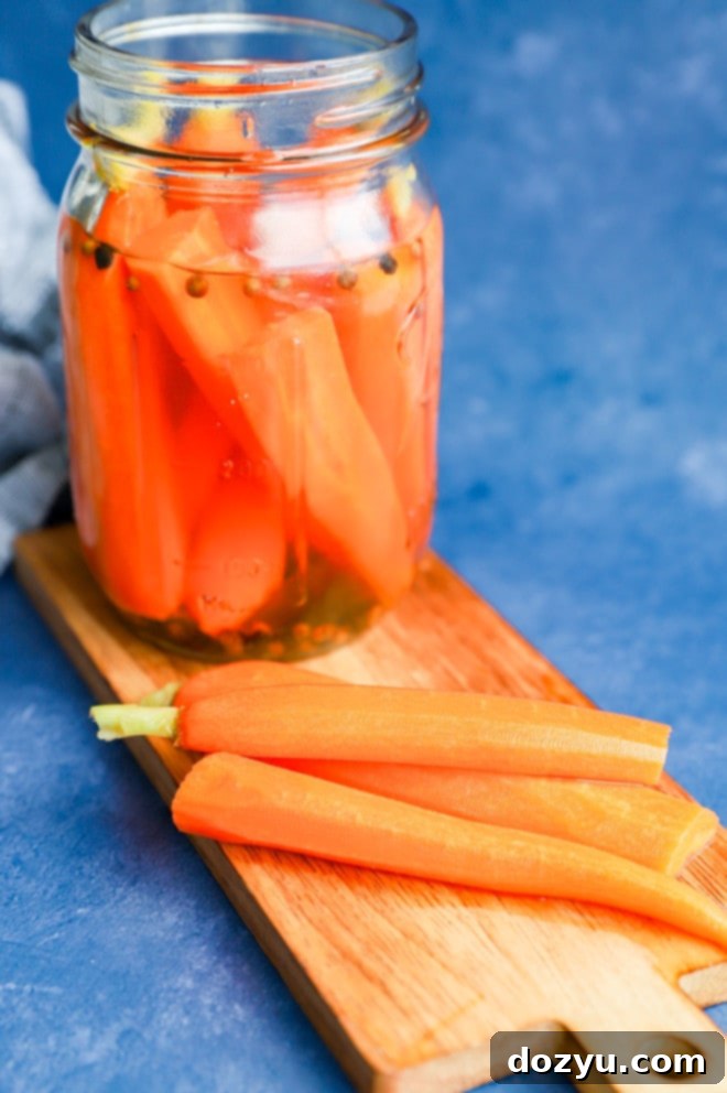 Zesty Quick-Pickled Carrots 6 Brightly colored pickled vegetables, including carrots, on a wooden cutting board, freshly removed from their brine.
