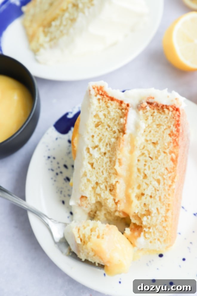 Fork taking a bit out of vanilla dessert with cream cheese frosting