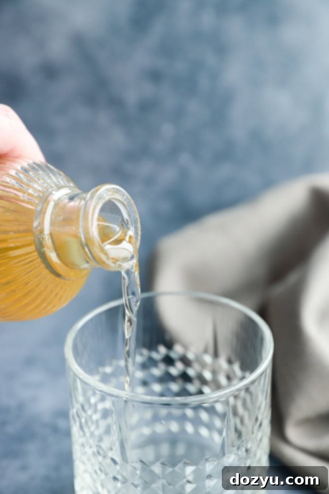 Vanilla simple syrup being poured into a cocktail glass, creating an elegant drink