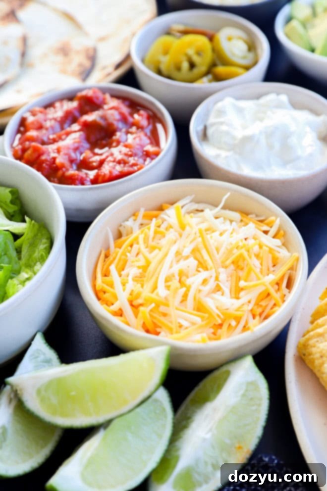 shredded cheese in a bowl with lime wedges