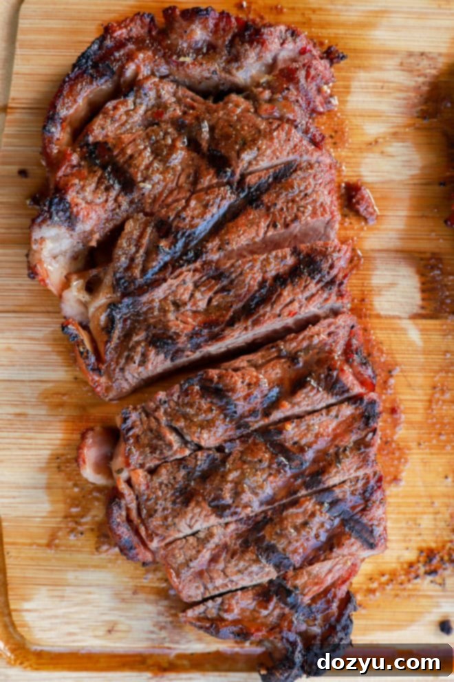 Perfectly Grilled New York Strip 9 sliced new york strip steak on a cutting board