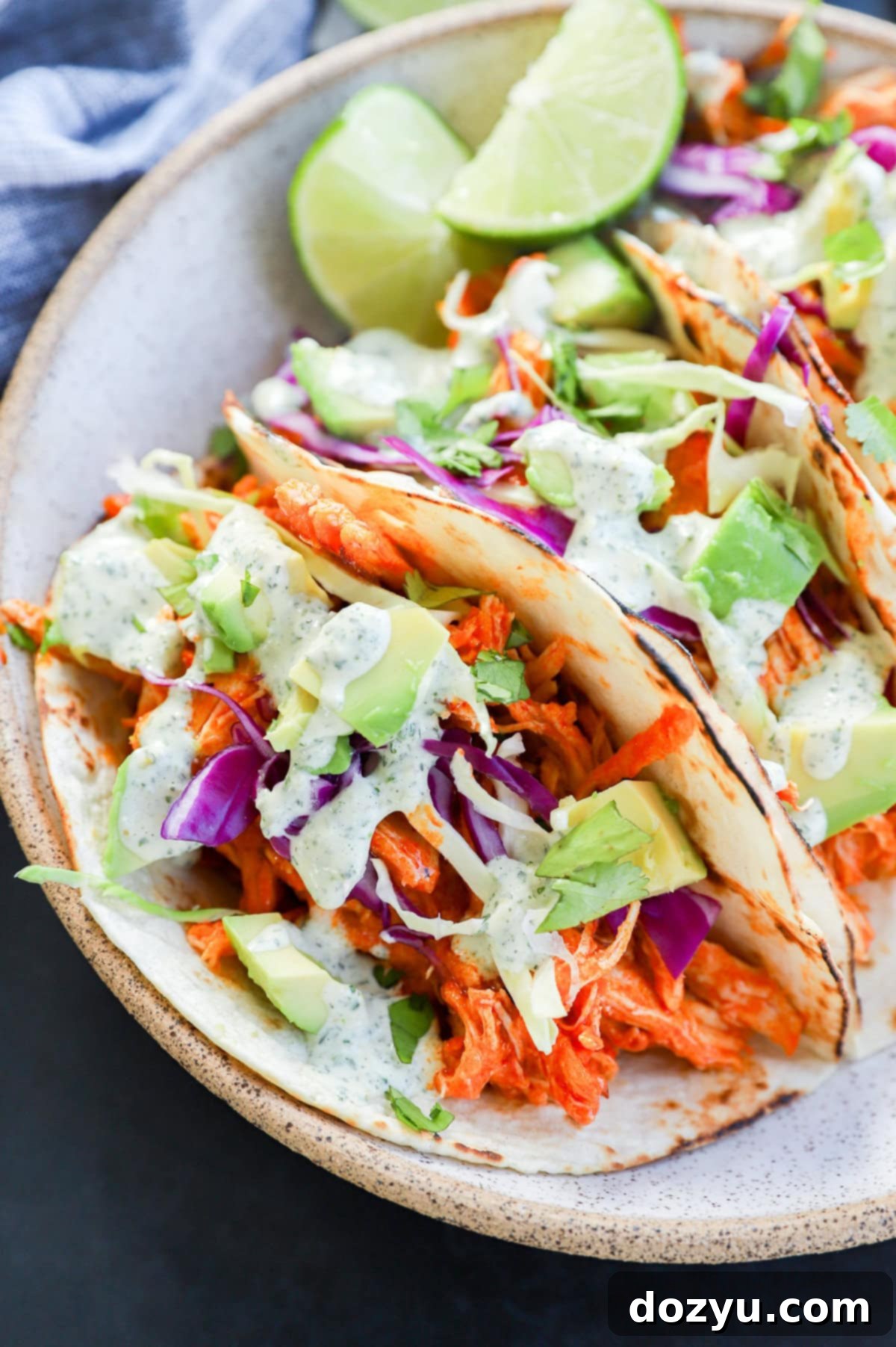 buffalo chicken tacos with cabbage and avocado on top