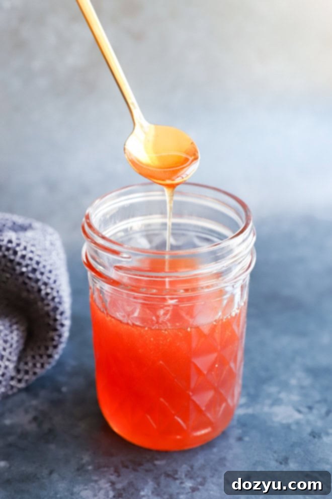 spooning hot honey with gold spoon from a jar