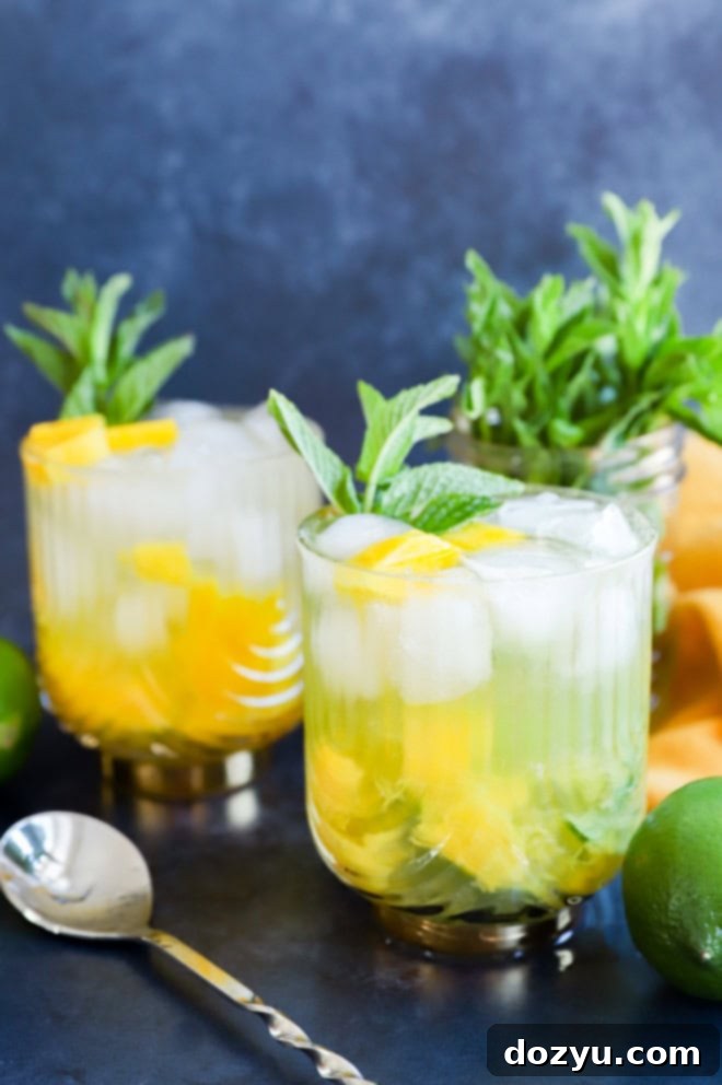 Tropical Mango Mojito 2 A beautifully garnished fruity cocktail with fresh mint sprigs and lime wedges, set against a bright, summery background.