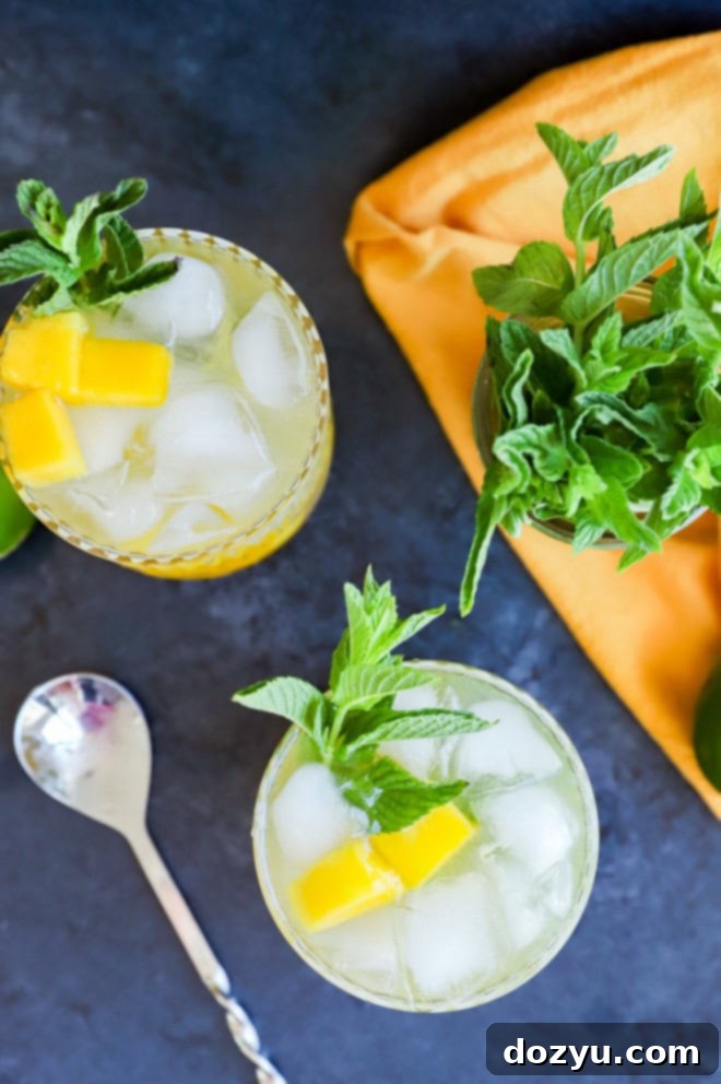 Tropical Mango Mojito 8 Multiple mango mojitos in glasses, garnished with fresh mint and mango pieces, arranged beautifully.