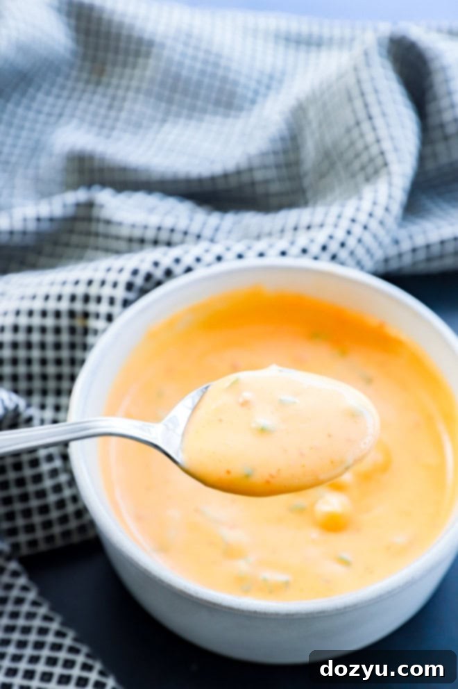 Spoon lifting spicy spread out of a bowl