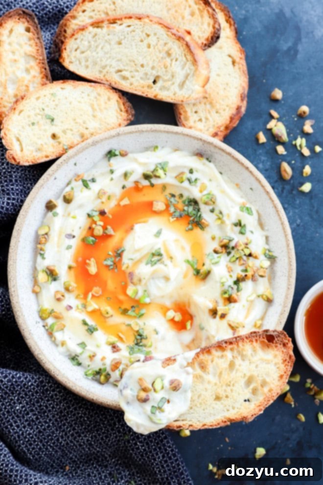 A toasted slice of baguette generously topped with creamy whipped ricotta, ready to be enjoyed.