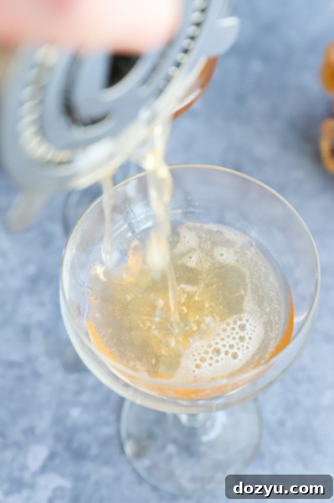 straining a cocktail into a coupe glass