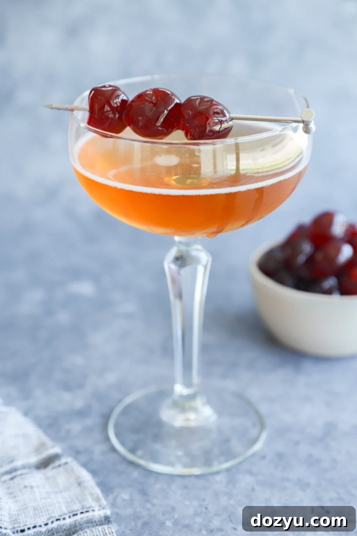 Low ABV cocktail in a coupe glass with cherry garnish