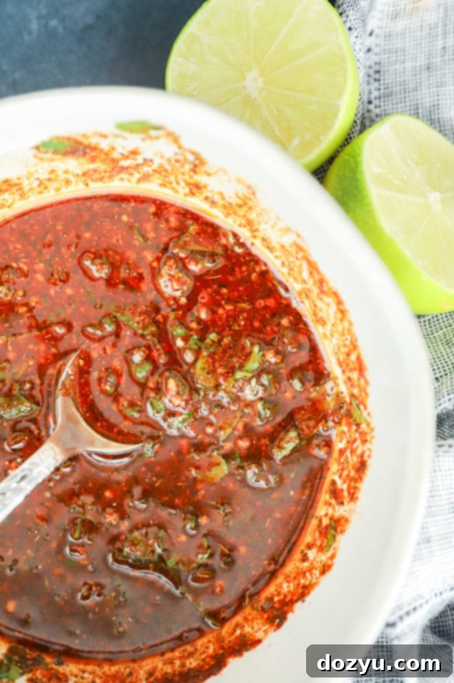 mexican chicken marinade in a bowl with spoon and fresh lime halves