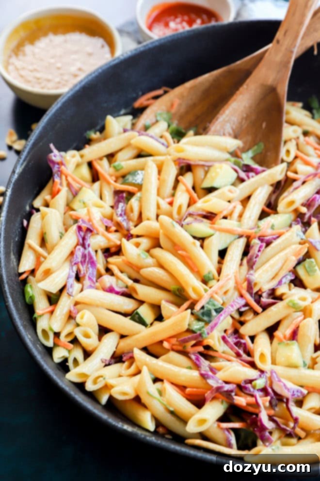 thai pasta salad in a large bowl with wooden utensils