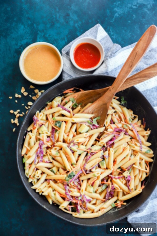 overhead image of bowl of thai pasta salad with serving spoons