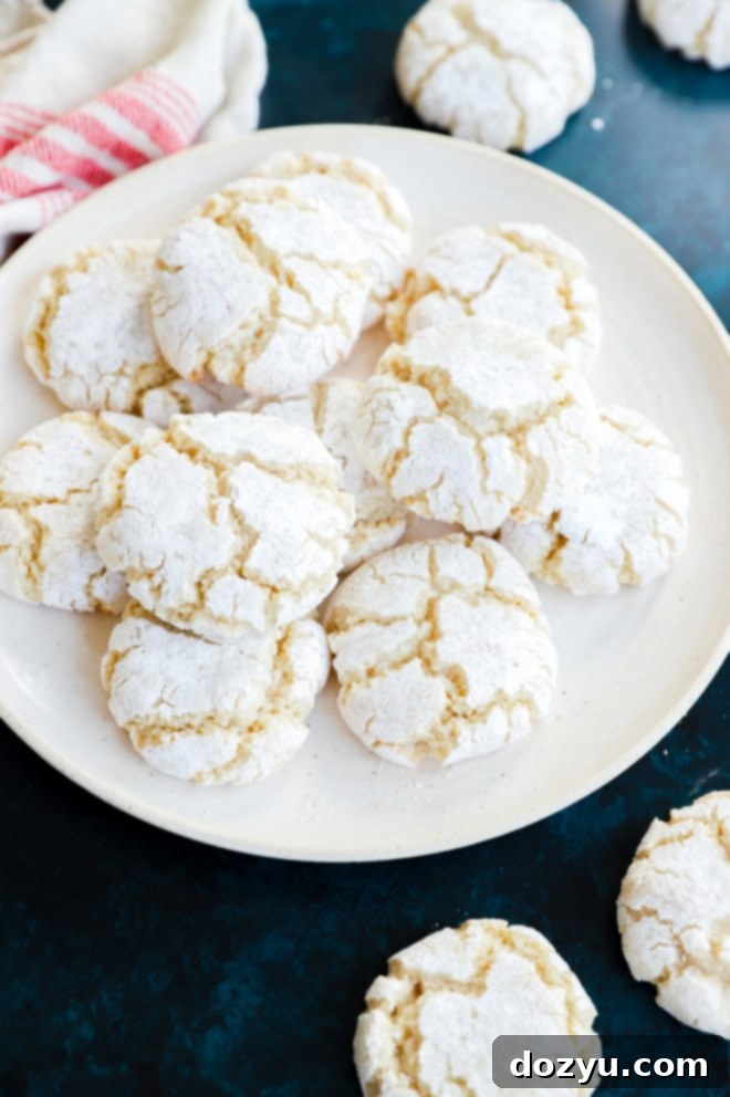 easy almond cookies on a plate with confectioners sugar