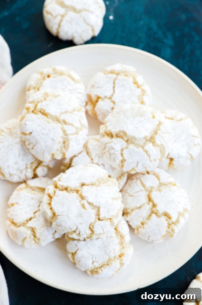 pretty cracked amaretti cookies on plate with linen and green countertop
