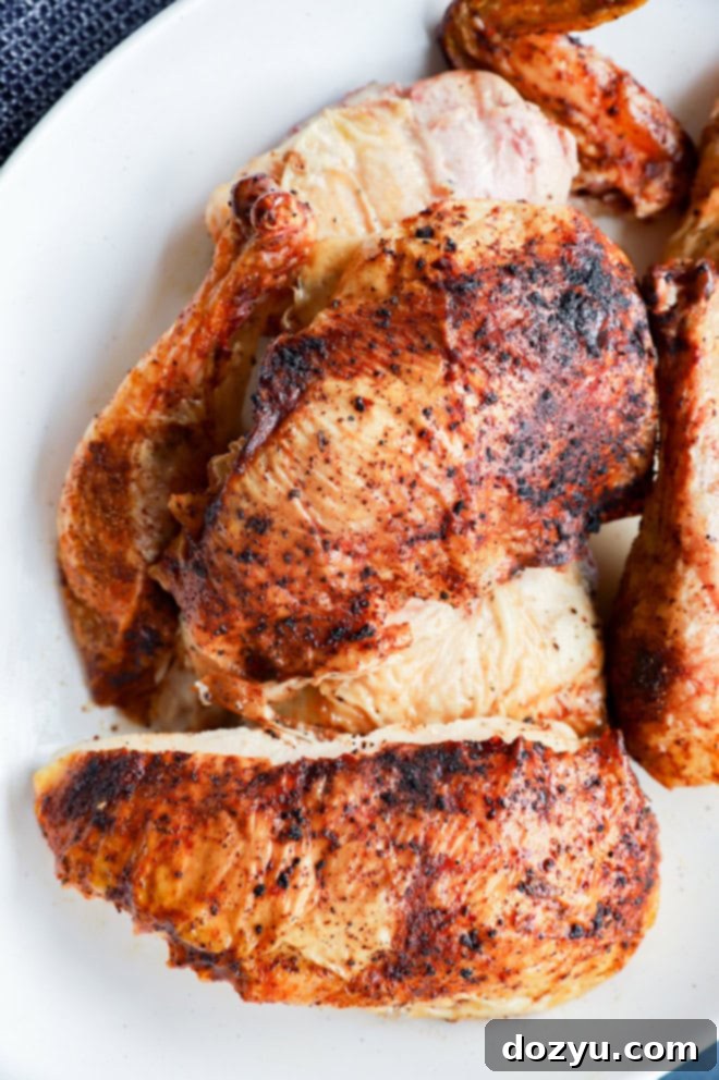 grilled full chicken on platter in pieces with utensils