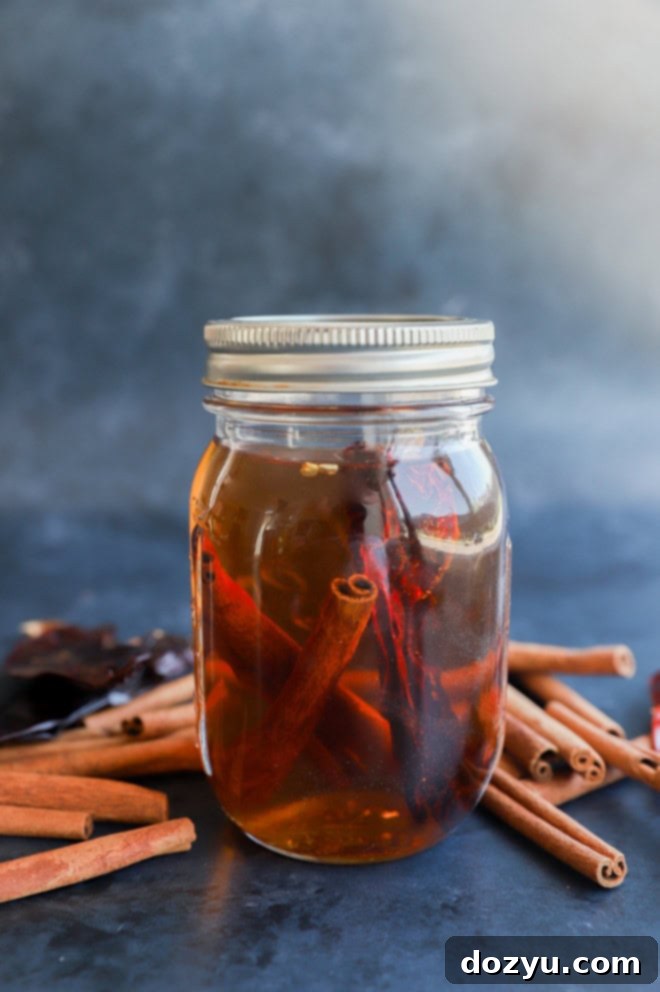 Homemade cinnamon whiskey infusing in a glass jar