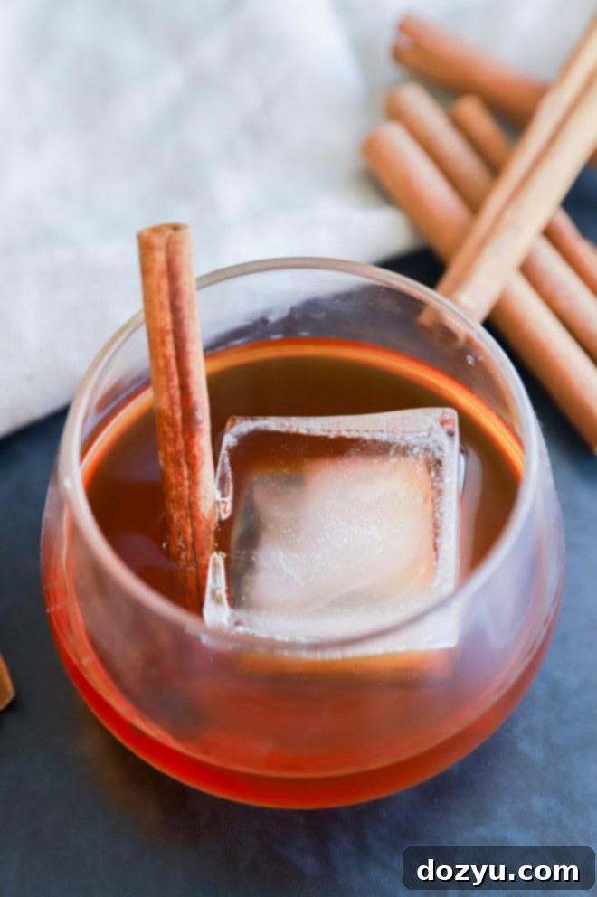 Homemade cinnamon whiskey in a glass garnished with a cinnamon stick