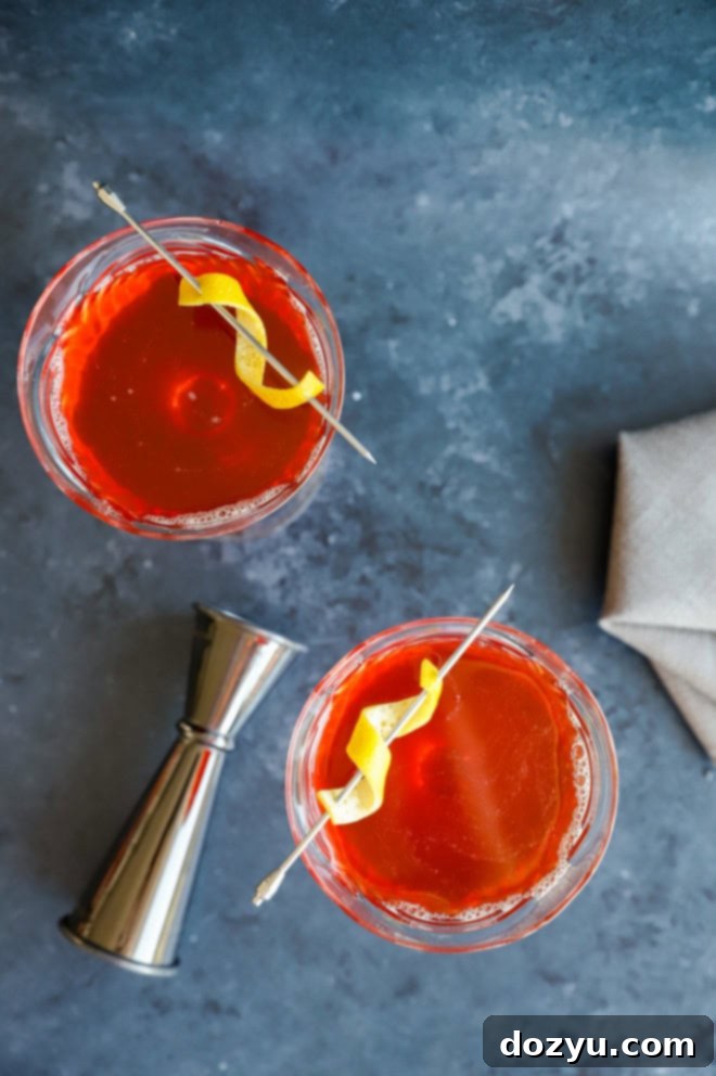 overhead image of coupe glasses with paper plane cocktails and jigger