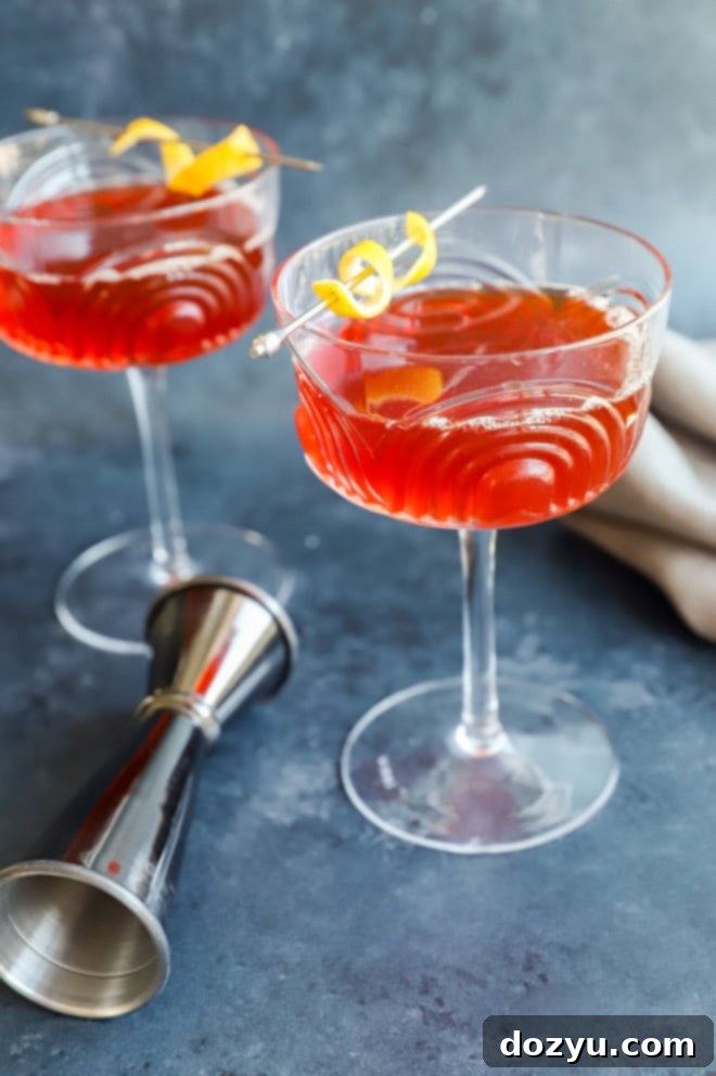 paper plane cocktail in coupe glasses with jigger and linen