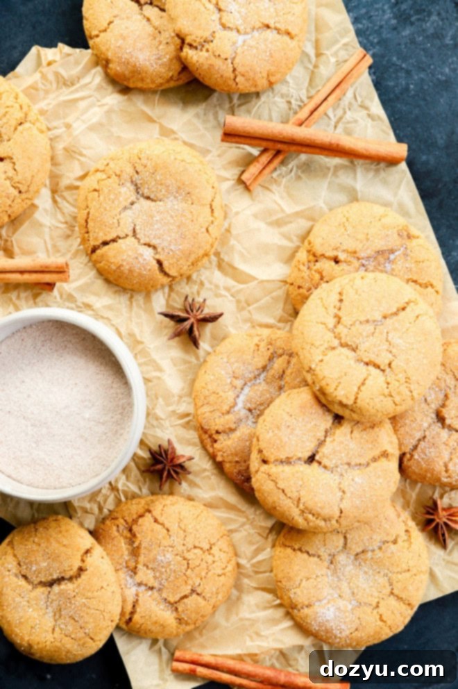 A charming stack of pumpkin pie spice cookies on parchment paper, with a sprinkle of cinnamon sugar.