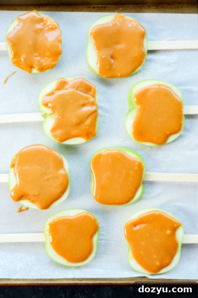 Caramel-coated apple slices with popsicle sticks inserted