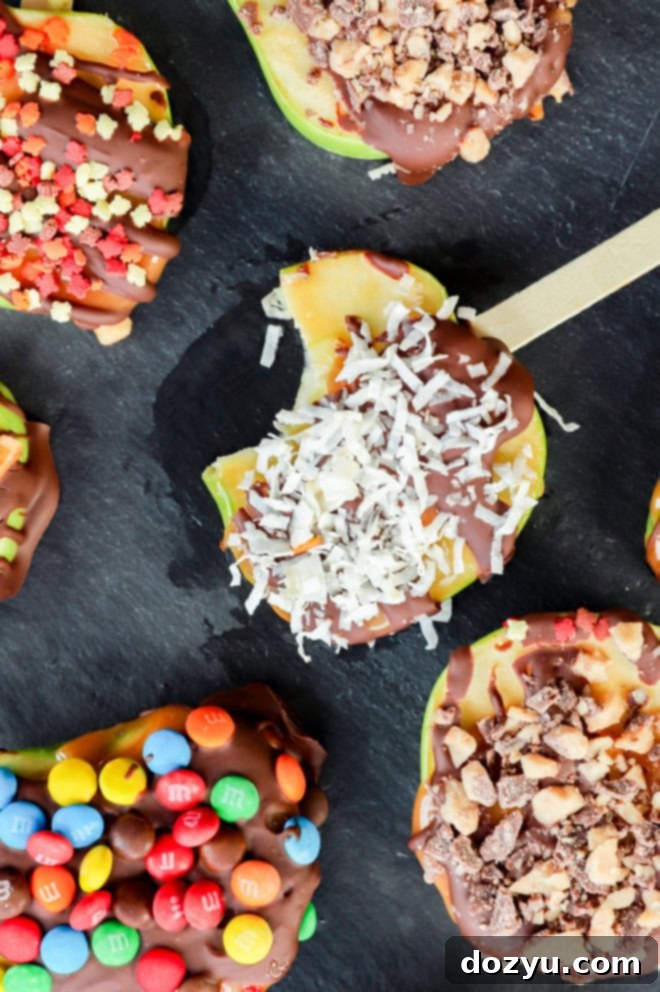 A candy apple slice with a bite taken out, showing caramel, chocolate, and shredded coconut
