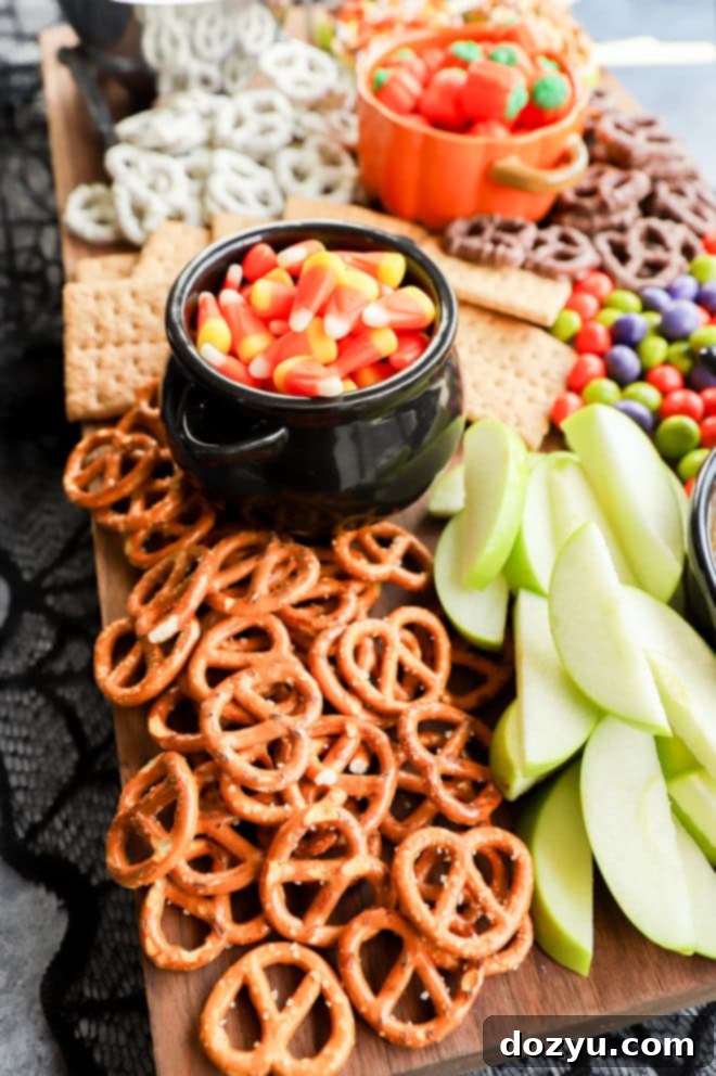 A festive snack platter laden with an assortment of Halloween sweets and treats, perfect for autumn gatherings.