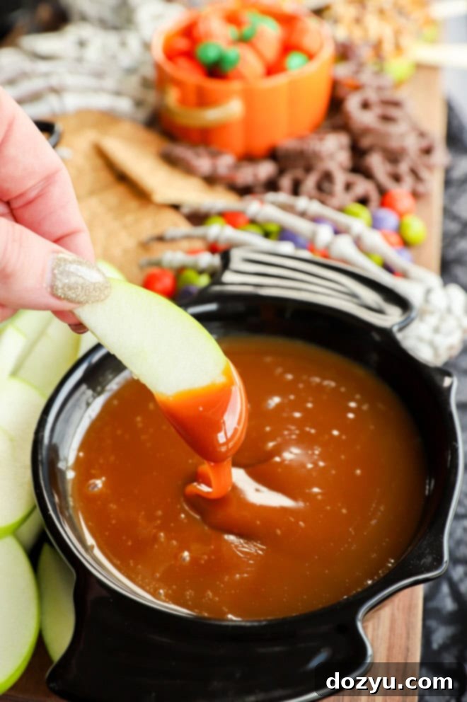 Hand gracefully holding an apple slice, dipping it into a luscious caramel apple dip, with a spooky skeleton hand subtly positioned in the background, adding to the Halloween theme.