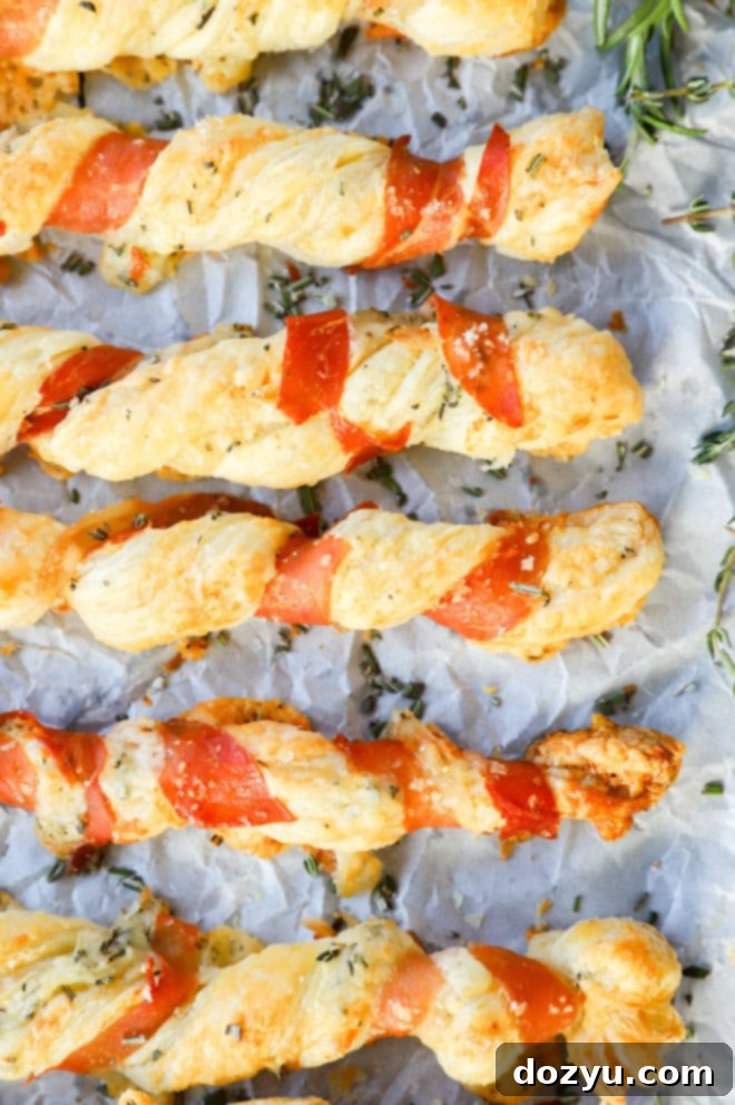 Flaky Prosciutto Cheese Twists 9 lined up puff pastry appetizers with cured meat and fresh herbs