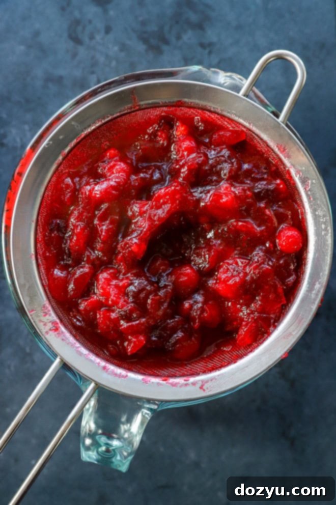 straining cranberry simple syrup