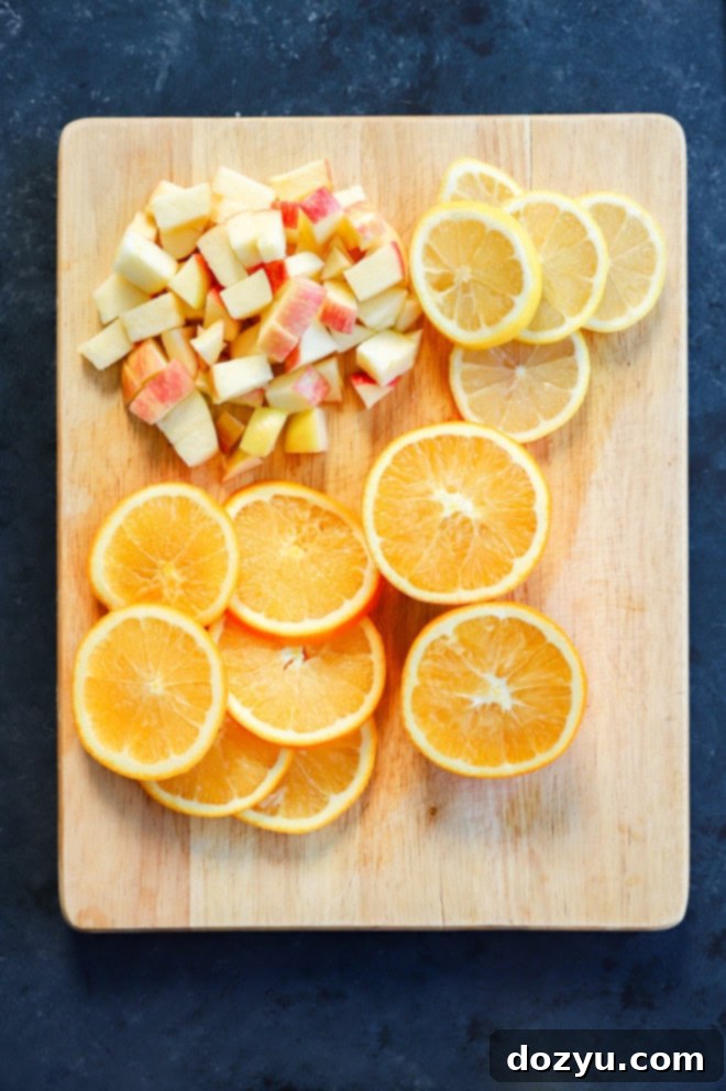 Ruby Red Sangria 3 sliced oranges, sliced lemon, and chopped apple on cutting board