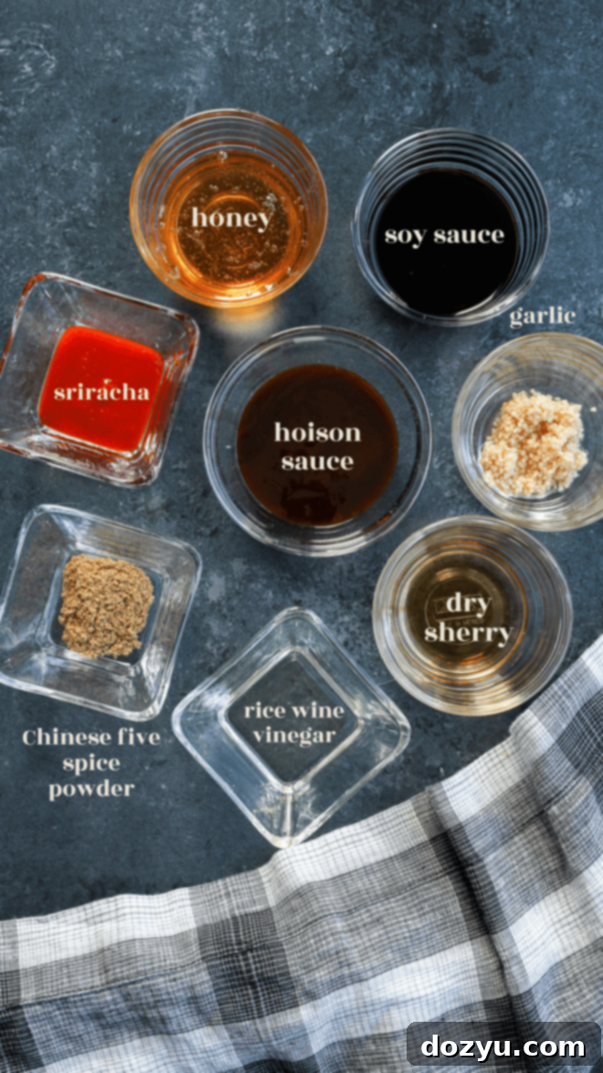 A collection of fresh ingredients laid out for Asian pork belly marinade preparation, including hoisin sauce, honey, soy sauce, dry sherry, rice wine vinegar, Chinese five spice, minced garlic, and sriracha.