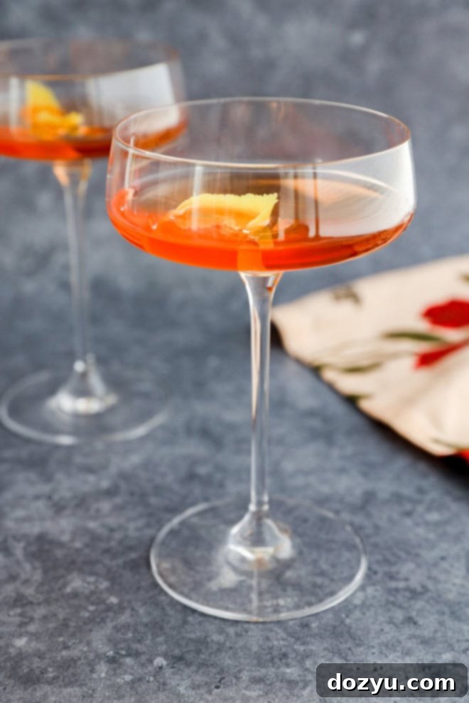 pink gin cocktail in coupe glasses with lemon twist