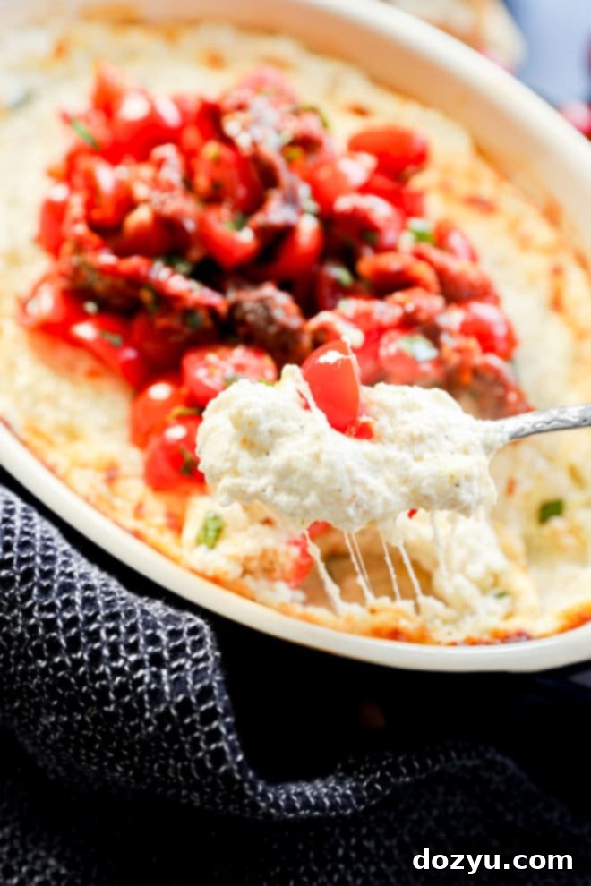 Irresistible Baked Goat Cheese Dip 7 gooey cheese pull with spoon of baked goat cheese appetizer dip
