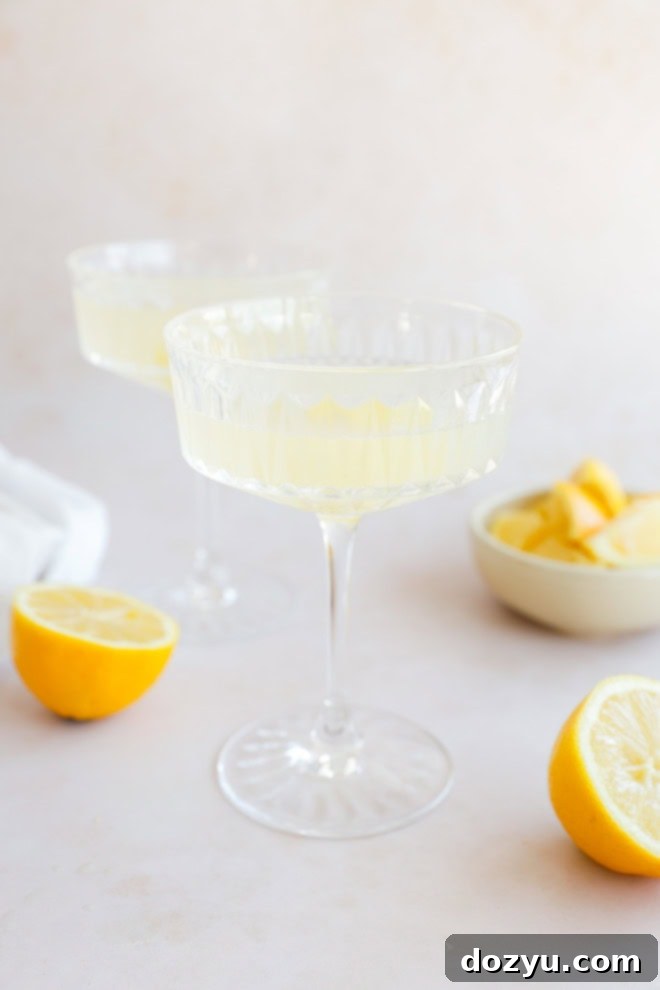 Sip on Perfection: The Bee's Knees Cocktail 6 lemony cocktail with fresh lemons in cocktail coupe glasses