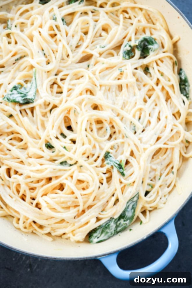 linguine with white cream sauce basil and spinach in a skillet