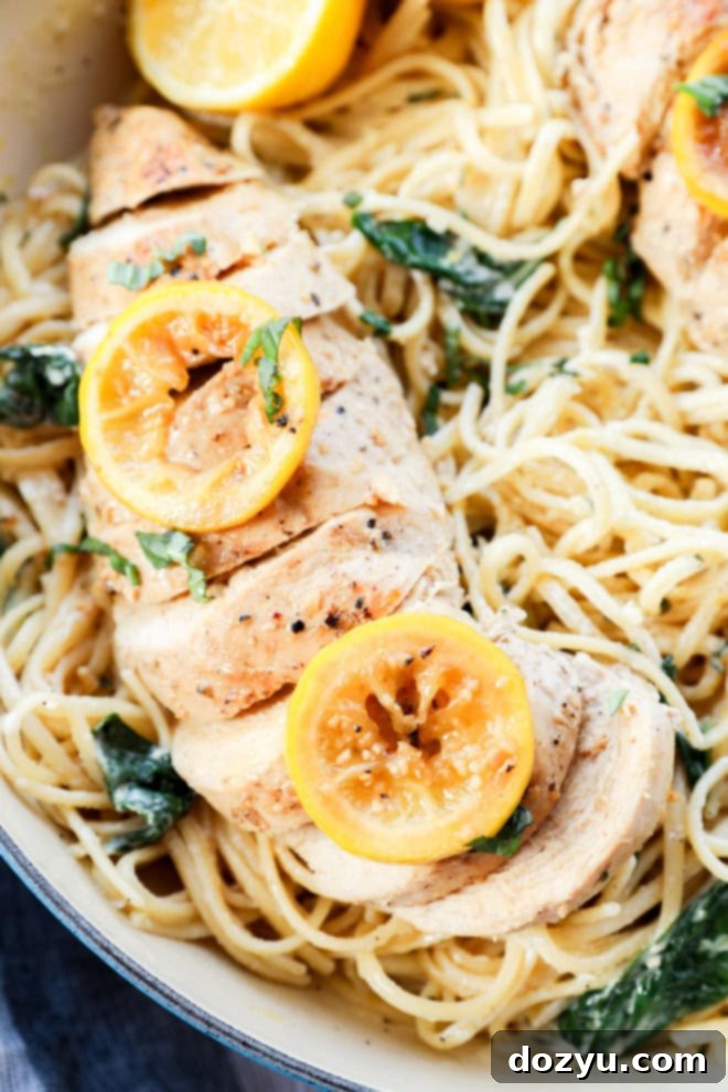creamy linguine with poultry sliced on top and fresh basil and spinach