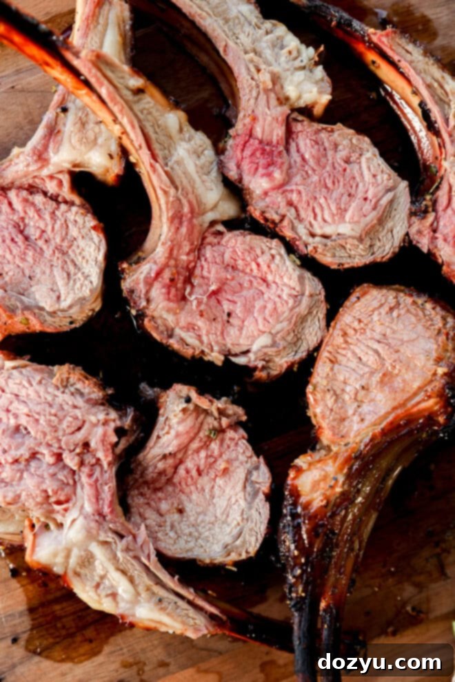 easy Easter meat dinner, sliced rack of lamb on a cutting board next to roasted vegetables