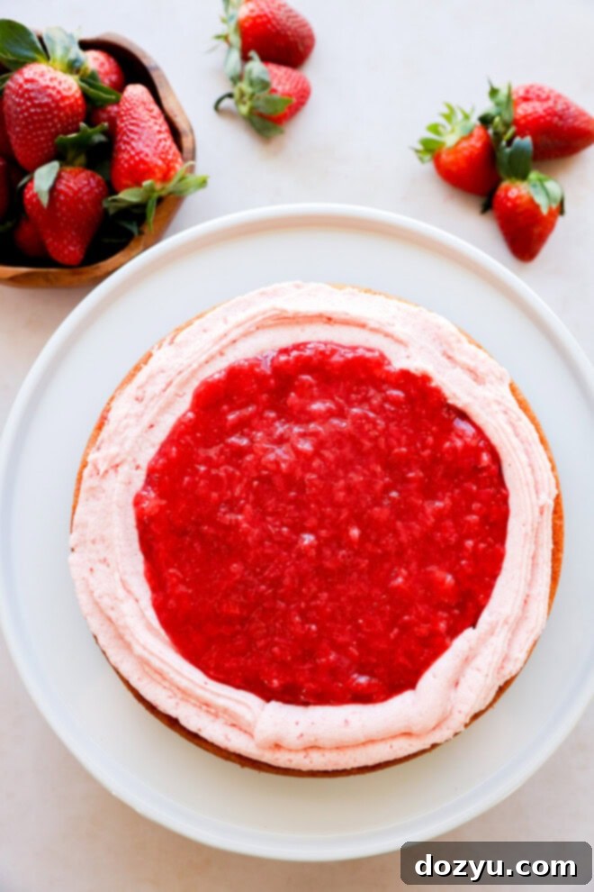 cake with strawberry filling and buttercream during layering process