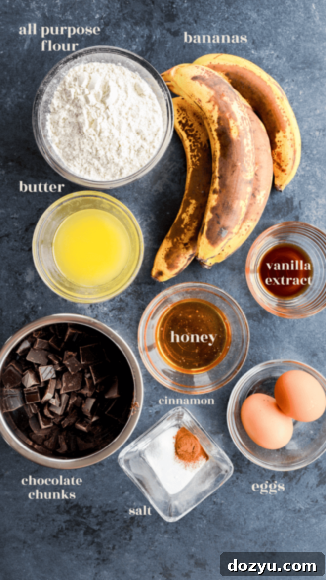 Various ingredients for banana chocolate chunk muffins laid out in bowls with descriptive labels