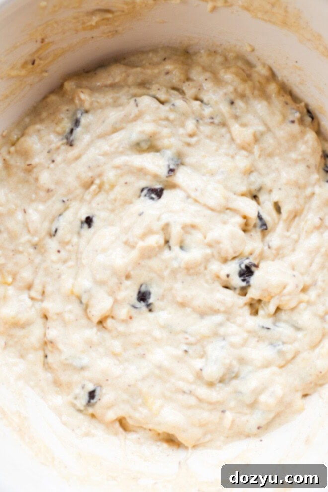 Close-up of fluffy banana chocolate chunk muffin batter in a mixing bowl, ready for baking.