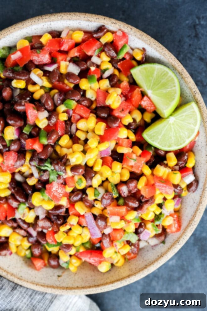 Southwestern Black Bean Corn Salsa Dip 5 easy appetizer with fresh vegetables in a bowl with lime wedges