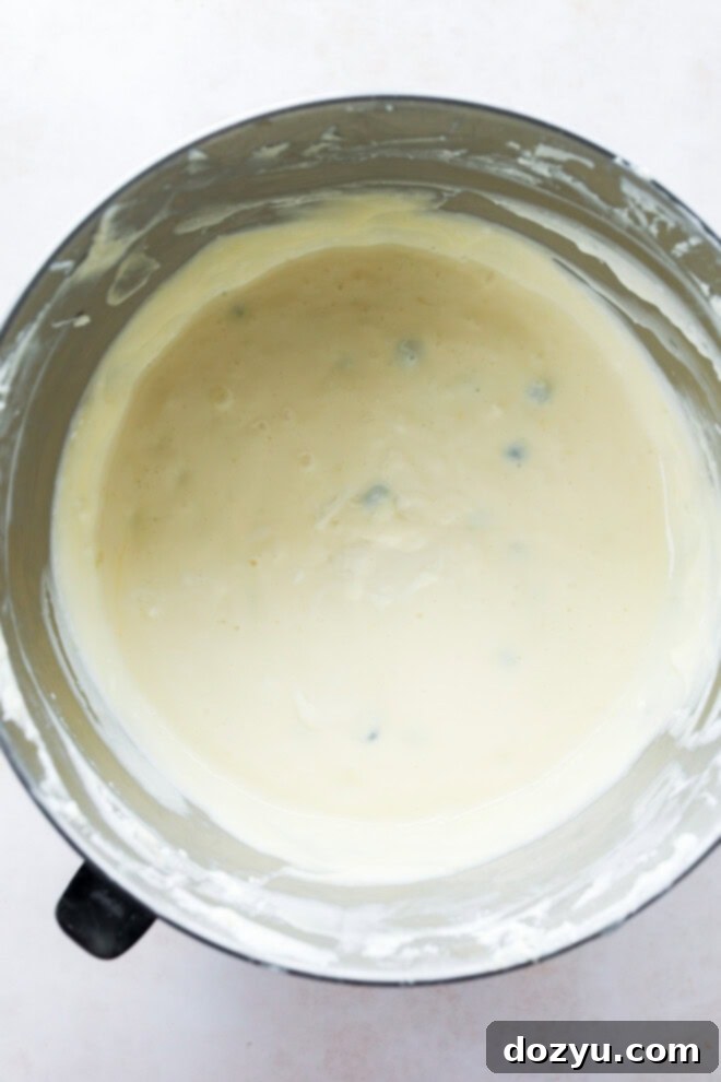 Luscious Lemon Blueberry Cheesecake 6 Smooth and creamy lemon blueberry cheesecake filling in a stand mixer bowl, ready for baking.