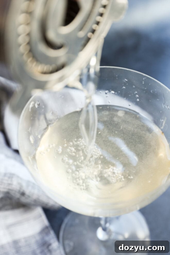 Classic Gin Martini 4 pouring a shaken dirty martini into a cocktail glass