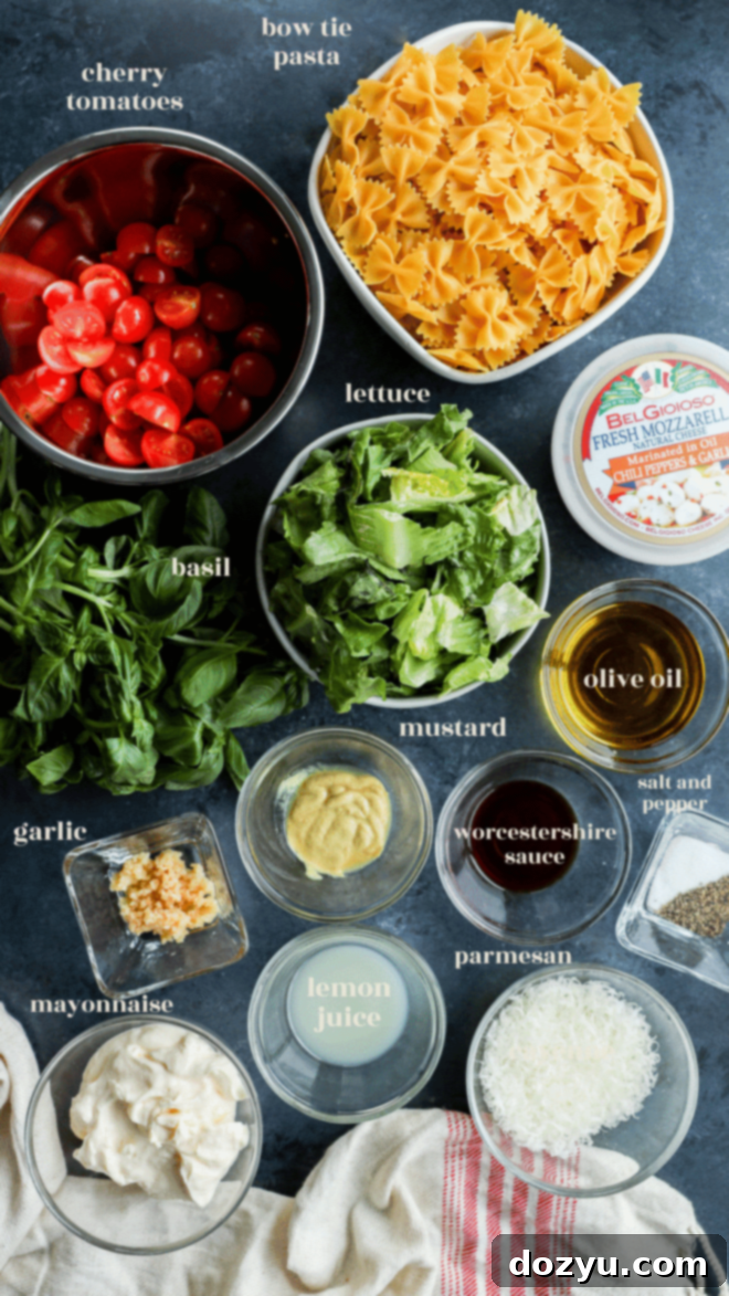 Sun-Kissed Caprese Bow Tie Salad 3 Caprese bow tie pasta salad ingredients laid out in separate bowls with text labels, including fresh basil, cherry tomatoes, mozzarella, romaine, and farfalle.